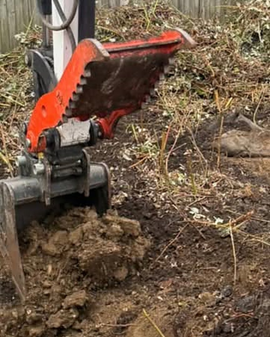 Maddan excavator clearing ground